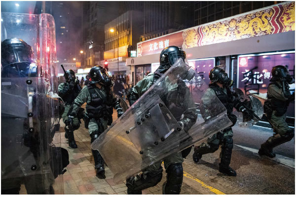 7月28日香港民眾在上環地區示威期間，全副武裝的香港警察在武力清場的過程中向前推進。（Getty Images）