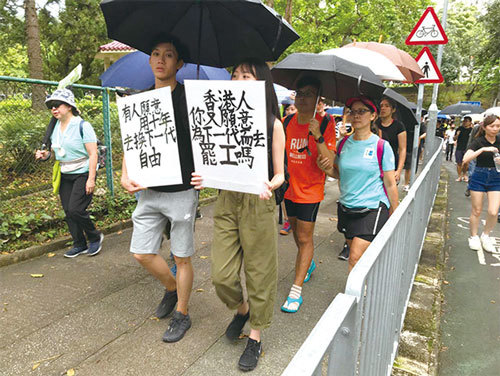 8月4日下午14時20分，遊行隊伍有市民拿著兩塊展板，分別寫著「有人願意用十年去換下一代自由」「香港人你又願意為下一代而去罷工嗎」。（蔡雯文／大紀元）