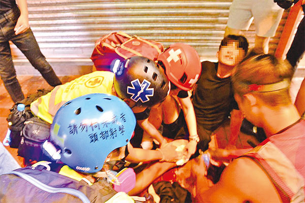 10月4日，香港便衣警察在元朗開車撞人後開槍打傷學生。事發當晚，被槍傷的14歲少年在現場接受護理。（余天佑／大紀元）