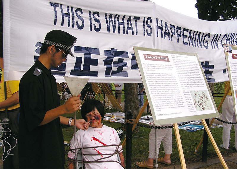 法輪功學員在中國大陸已遭受18年最殘忍的酷形迫害。圖為2004年7月20日，法輪功學員在美國首都華盛頓DC以酷刑展方式揭示中共殘酷迫害法輪功的真相。（李莎／大紀元）