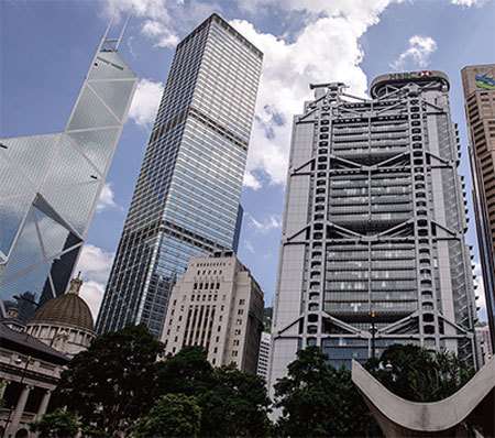 中共央行設在香港、外形酷似尖刀的中銀大廈（左）有風水設局。鄰近的匯豐銀行（右）在樓頂設置「風水炮」以對抗中銀大廈這把尖刀。中間的長江集團中心大樓則呈「四方臺盾形」碉堡。（AFP）