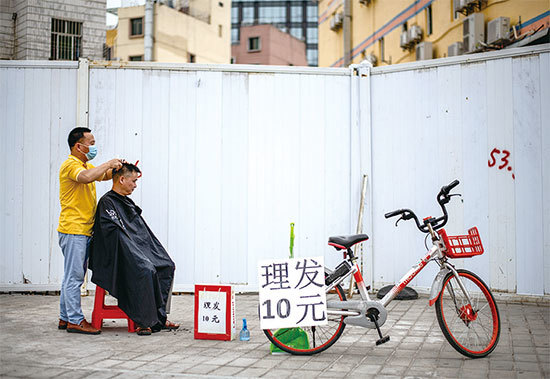 習近平深圳此行是為總結改革開放經驗，為何強調「自力更生」？圖為深圳街頭剃頭小販。（AFP）