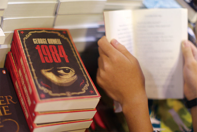 香港一名男孩在書店翻閱喬治．歐威爾名著《一九八四》。（AFP）