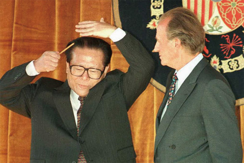 江多次在外交場合醜態百出。1996年6月24日江澤民訪問西班牙，在國王檢閱三軍儀仗隊時，突然拿出梳子梳理頭髮，成為國際笑談。（AFP）