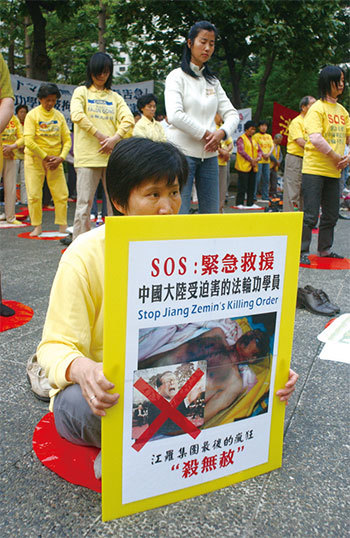 2002年3月，長春法輪功真相電視插播事件後，江澤民密令「徹底剷除」、「可以開槍打死」、「殺無赦」。圖為2002年4月12日，法輪功學員在香港集會遊行呼籲救援。（Getty Images）