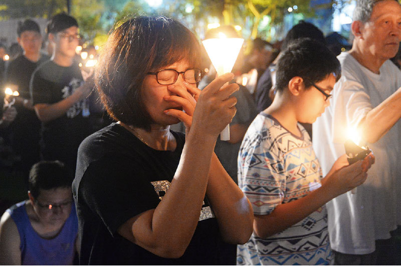6月4日，萬點蠋光再次照亮香港維多利亞公園，很多香港民眾一家人都來了，母親忍不住哭泣。（宋碧龍／大紀元）