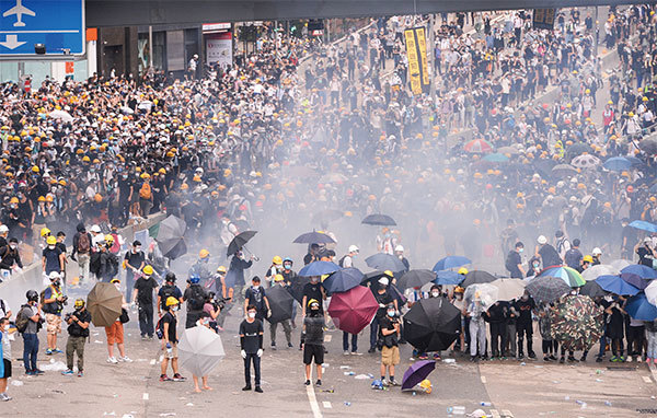 2019年6月12日，上萬民眾抗議港府執意修例，警方發射催淚彈驅趕，有民眾扔回催淚彈。（宋碧龍／大紀元）