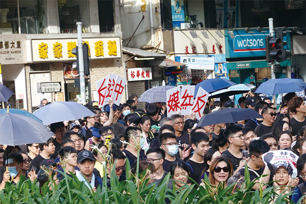 圖7：2019年7月21日，香港，民陣發起的反送中遊行隊伍中，民眾拿著寫有「反送中」及「反紅媒」的標語表達抗議。（余鋼／大紀元）