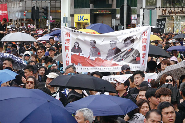 圖8：2019年7月21日，香港，民陣發起的反送中遊行隊伍中，有民眾拉起「出賣香港人 禍港四人幫」的橫幅表達抗議。（余鋼／大紀元）