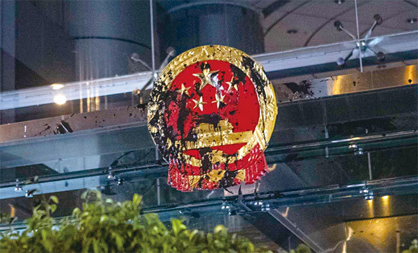 香港反送中運動已把衝擊矛頭指向中共中央。圖為7月21日反送中遊行後，晚間有示威者聚集中聯辦，中共國徽標誌被噴黑。（余鋼／大紀元）
