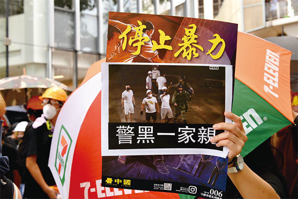7月28日香港反送中民眾拿停止暴力和警黑一家親的標語牌。（宋碧龍／大紀元）