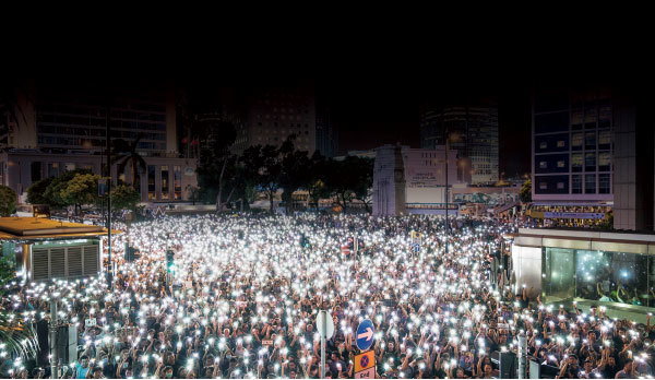 8月2日公務員集會集會至晚上9時許結束，發起人在臺上呼籲參加者和平散去。人們舉起手機，點點星光照亮遮打花園。（Getty Images）