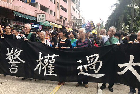8月3日，香港，「旺角再遊行」，一群銀髮族老人拉著「警權過大」橫幅為前導，喊著口號，為年輕人擋槍擋子彈。（林怡／大紀元）