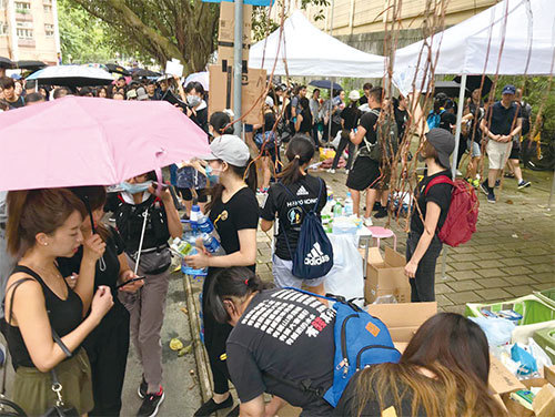 8月4日，遊行沿途市民互助互愛，有人自發擺設街站，免費派發水、運動飲料，甚至還有能量條、水果等食物，供遊行市民消暑充飢。（蔡雯文／大紀元）