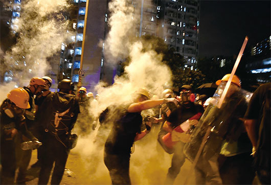 香港民間發起8月5日全港民眾「大三罷」活動，罷工、罷課、罷市。警方持續施放多枚催淚彈後，圖為黃大仙處示威者扔回催淚彈。（Getty Images）
