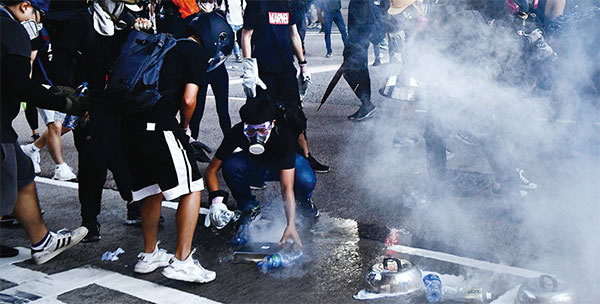 8月5日17時50分，警方在金鐘夏慤道一再施放催淚彈。示威者衝上去熄滅催淚彈。（Getty Images）