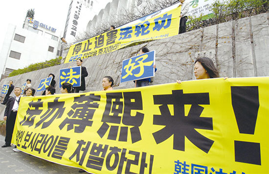 薄熙來被免職後，2012年3月24日即有消息稱，溫家寶曾在中共高層提平反「六四」及「平反法輪功」。圖為2007年4月10日，溫家寶訪問韓國首爾，法輪功學員在其下榻的酒店外促請法辦薄熙來。（AFP）