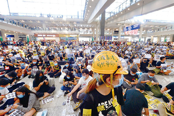2019年8月9日，香港機場「萬人接機」，參加者持各式海報和標語在大堂靜坐。（宋碧龍／大紀元）
