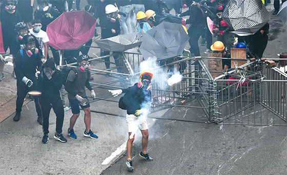 2019年8月11日，香港深水埗，群眾將警方發射的催淚彈扔擲回去。（AFP）