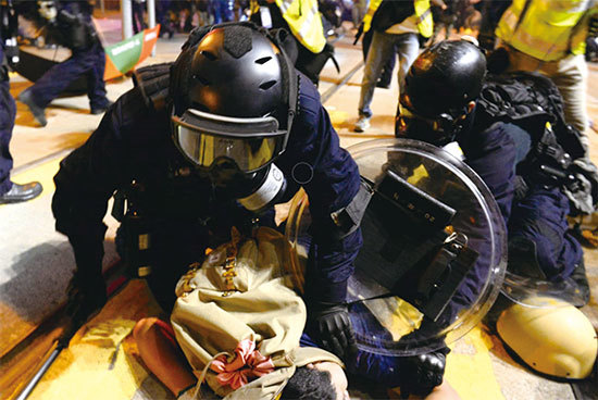 警方速龍小隊使用強硬武力驅散、拘捕抗議者，甚至在制服抗議者後仍以警棍毆打，這些警察沒有警員編號，頭盔、眼罩也遮蓋住臉部。圖為7 月28日晚，香港警察撲倒壓制示威者。（宋碧龍／大紀元）