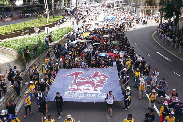 2019年7月1日，香港七一大遊行領頭的隊伍舉著向天橫幅，寫有「撤回惡法 林鄭下台」的遊行訴求。（余鋼／大紀元）