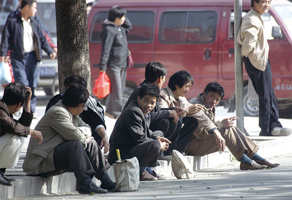 失業的大陸勞工在北京的一條街上等待工作機會。（AFP）