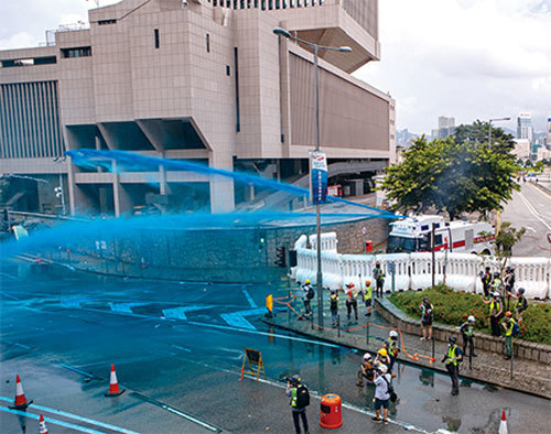 8月31日，港警在香港政府總部外對抗議民眾發射藍色水砲。（余鋼／大紀元）
