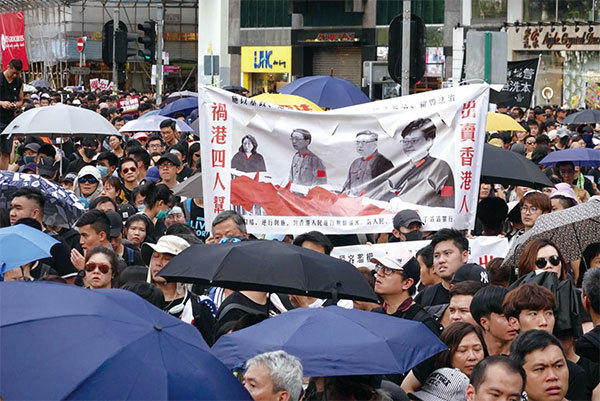 7月21日，民陣發起的反送中遊行隊伍中，有民眾拉起「出賣香港人 禍港四人幫」（左二為李家超）橫幅表達抗議。（余鋼／大紀元）
