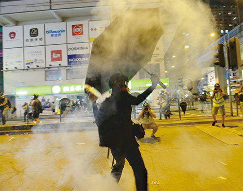 9月6日，港人在太子站要真相，港警發射催淚彈。圖為一名黑衣人把催淚彈丟回警方。（宋碧龍／大紀元）