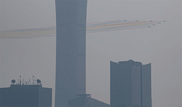 10月1日中共舉行閱兵式，北京城被陰霾籠罩。圖為天空中的彩色飛機陣。（AFP）