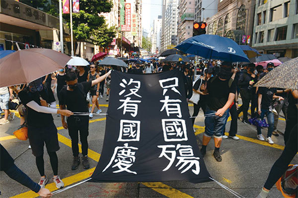 10月1日中共在香港露出殺虐的邪惡基因，把香港變成戰場。中共精心安排歌舞昇平「壽宴」，最終還被香港抗爭市民搶走風頭。圖為香港遊行民眾自製「沒有國慶 只有國殤」的標語。（宋碧龍／大紀元）