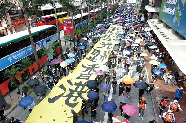 香港10月5日「全民蒙面遊行」，民眾拉起「我願榮光歸香港」大型條幅。（余鋼／大紀元）