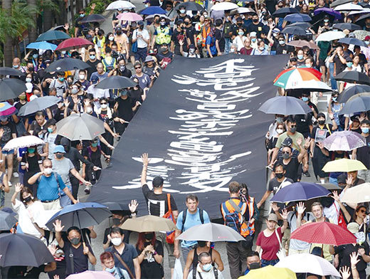 香港10月5日「全民蒙面遊行」，民眾拉起「香港警察蓄意謀殺」大型條幅。（余鋼／大紀元）