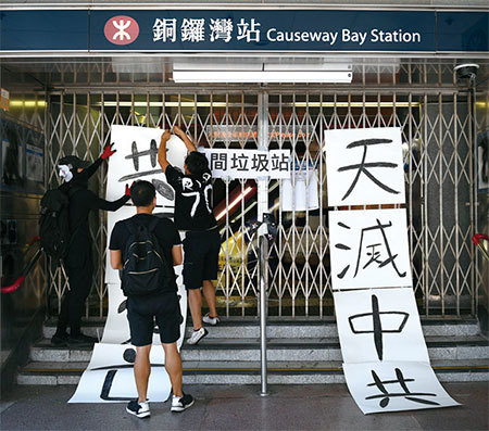 香港街頭標語「天滅中共」令中共極度恐懼。圖為10月1日香港「沒有國慶 只有國殤」遊行，有抗爭者在關閉的銅鑼灣地鐵站口布置標語牌「天滅中共」。（AFP）