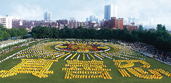 1996年，五千多名武漢法輪功學員集體煉功，列隊組字。上部分為法輪圖形，下部分為「真、善、忍」。（明慧網）
