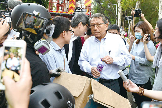 11月12日，中大校園遭港警炮火猛攻，學生撿拾收集成箱的催淚彈殼給校長段崇智看。（宋碧龍／大紀元）