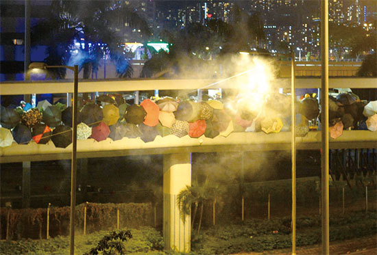 11月17日，防暴警察和抗爭者在尖東橋對峙，防暴警察射擊催淚彈。（宋碧龍／大紀元）