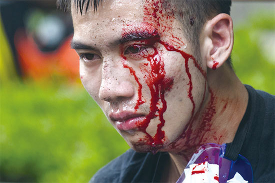 11月18日，一名抗爭者被暴警打到頭破血流，之後被捕帶走。（AFP）