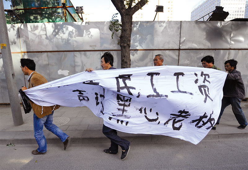 如老馬一樣的農民工不僅要回了工資，也認識了神奇的法輪功，並從心裡欽佩老馬這個法輪功修煉者。圖為一群農民工在北京陳情抗議黑心老闆積欠工資。（AFP）