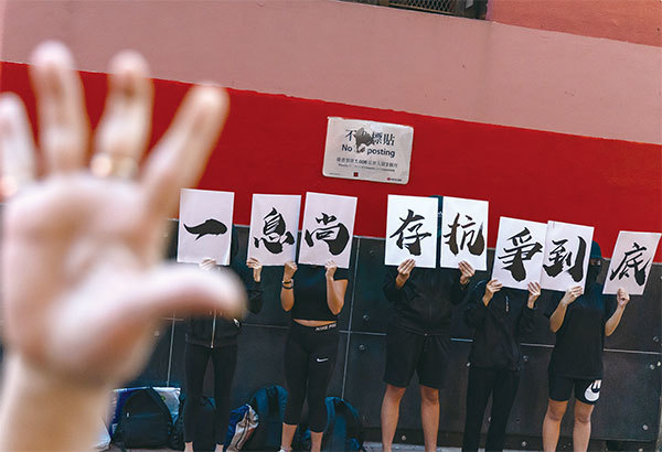 6月12日反送中周年活動，香港年輕人舉出標語「一息尚存，抗爭到底」表達心聲。（Getty Images）