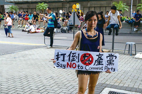 香港年輕一代人原本對分析共產黨沒興趣，但經歷2014年雨傘運動及去年反送中抗爭，越來越認清共產黨邪惡本質。圖為2014年9月27日港女訴求「打倒共產黨」。（AFP）
