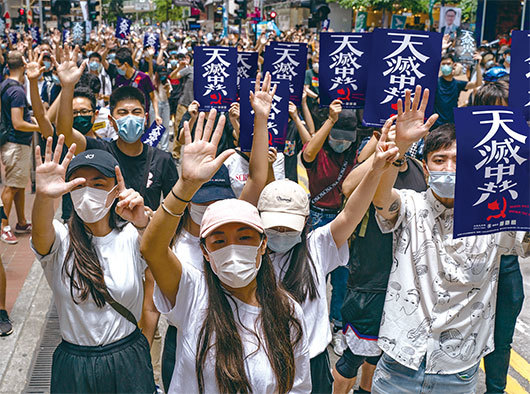 袁弓夷此行要透過美國國會、法庭把共產黨定性為反人類犯罪集團，與班農擬定「天滅中共運動」。圖為5月24日上萬香港人遊行反對港版國安法，「天滅中共」標語隨處可見。（AFP）