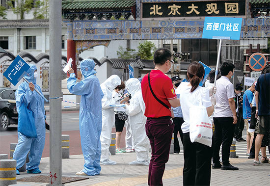 北京新發地在疫情爆發後的兩天內就檢出超過70例病例，北京各核酸檢測點擠滿了人。（AFP）