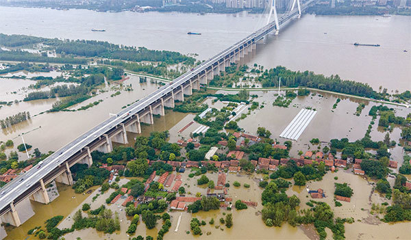 人民生活動盪，各種災難齊降。圖為2020年7月13日被洪水淹沒的武漢天興洲島空拍圖。（AFP）