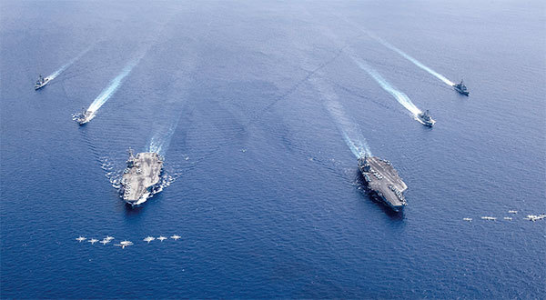 7月4日，美國尼米茲號航空母艦（右）和里根號航空母艦（左）在南海菲律賓海域舉行「雙航母」聯合軍演。專家普遍認為這是為了震懾中共而來。（US NAVY / AFP）