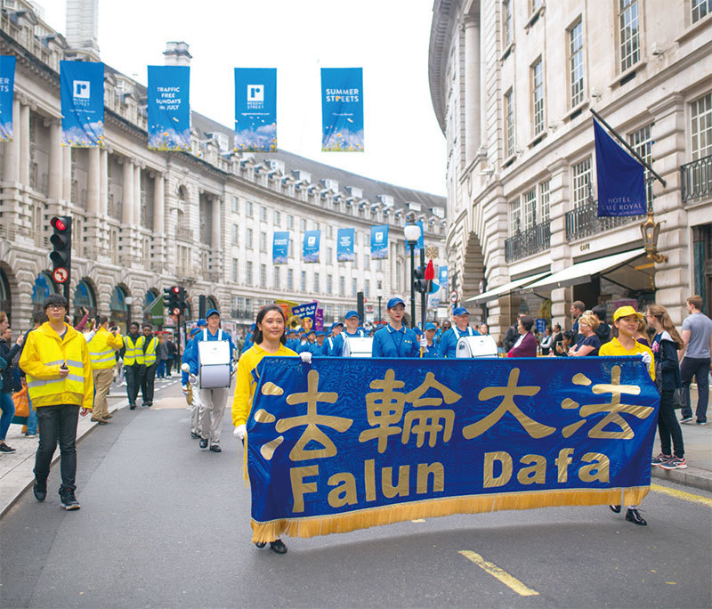 7月23日，歐洲天國樂團與英國部分法輪功學員近200人的遊行隊伍穿過倫敦市中心，呼籲制止中共對法輪功的迫害，立即停止活摘法輪功學員器官，活動得到民眾關注及六位英國議員的支持。（Laphare／大紀元）