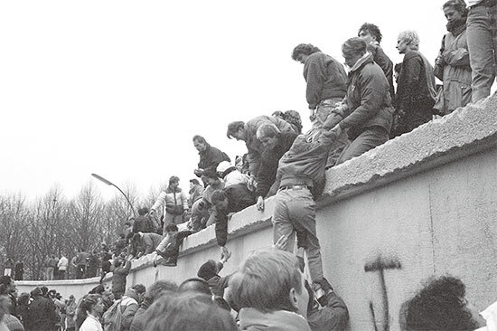 美國國會議員李賓斯基說，共產主義的恐怖尚未結束，「今天，香港就是新的柏林。」圖為東柏林人1989年12月31日爬上柏林圍牆，慶祝柏林牆倒塌。（Getty Images）