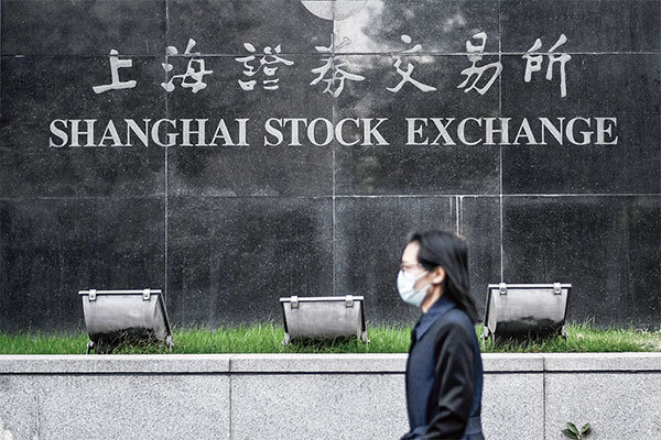 中國將全面實行股票發行註冊制。專家預測，這為中共超發的貨幣找到了新的蓄水池。圖為一行人走過上海證券交易所。（Hector Retamal / AFP）