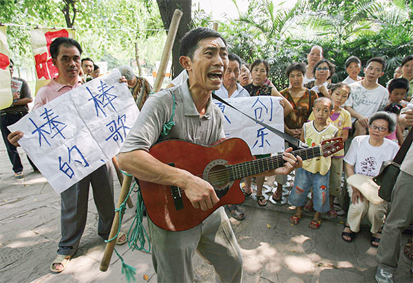 重慶山城有十萬挑夫大軍，挑夫是重慶典型的勞動者，「棒棒」就是挑夫肩上擔的棒子暱稱。圖為因唱歌而成為知名挑夫的黃金偉。（China Photos/Getty Images）