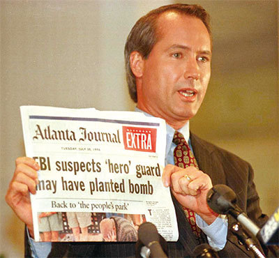 林伍德1996年為一名在奧運公園爆炸事件中從英雄變成嫌犯的杰威爾打官司，最終使美國總檢察長公開道歉。圖為他當年10月28日在記者會上手持《亞特蘭大日報》。（Doug Collier/AFP）